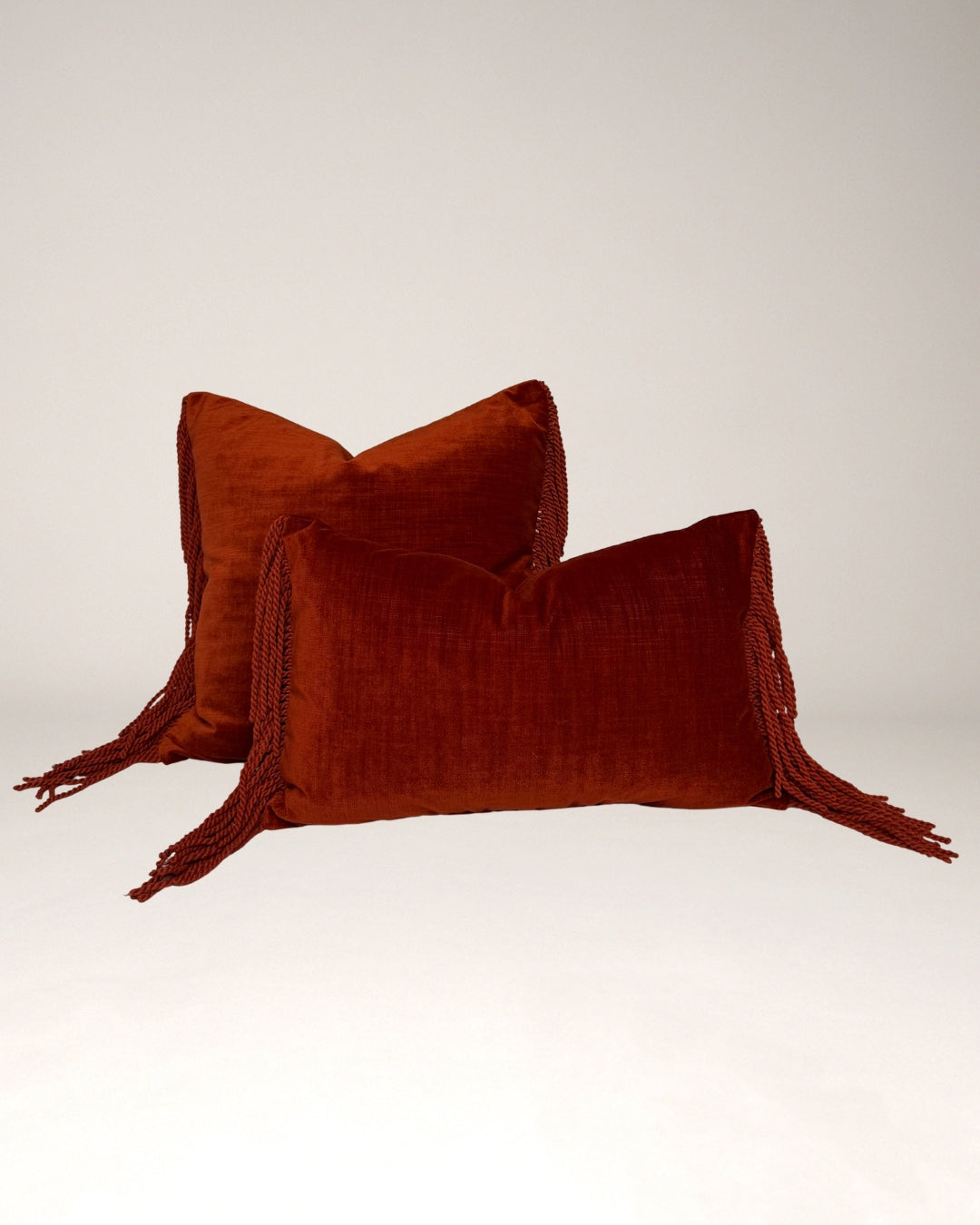 Terracotta Hogaría sierkussen met luxe fluwelen textuur en lange franjes aan de zijkanten, handgemaakt in Nederlandse ateliers. Premium decoratief kussen voor sofa of bed, duurzaam gevuld en ontworpen voor een warme, high-end interieurstijl.